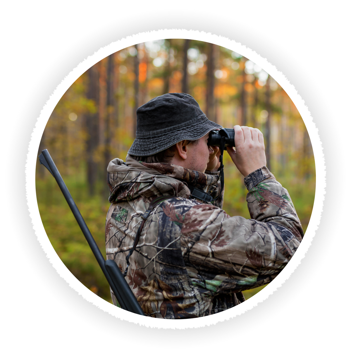 A circular photo of a person in a woodland camouflage jacket and bucket hat using binoculars in a forest, shown on a white background with a drop shadow.